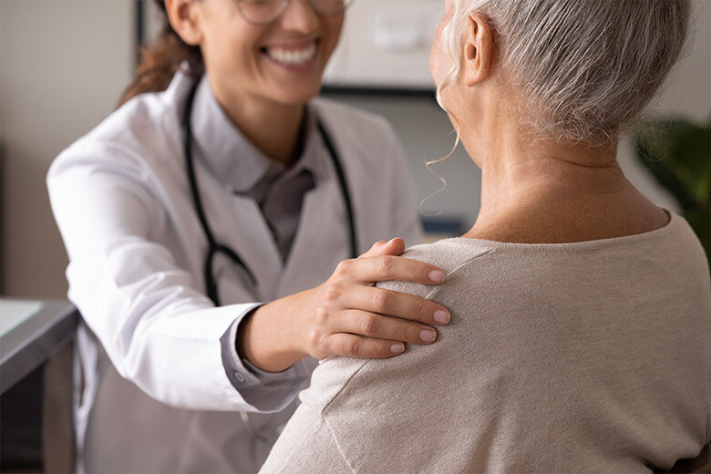 A doctor puts a reassuring hand on a patient's shoulder